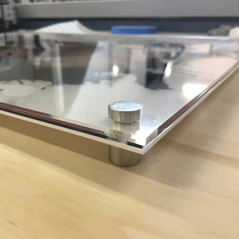 Metallic cylindrical object on a reflective surface with a blurred background
