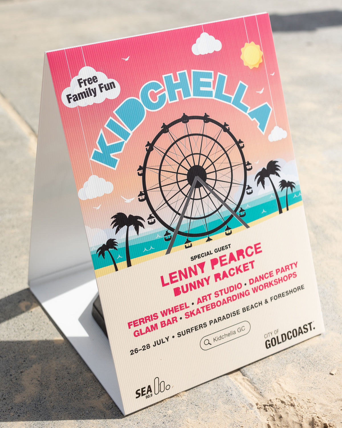 A vibrant Corflute A-Frame promotes Kidchella, a free family event at Surfers Paradise Beach (26–28 July), with a ferris wheel graphic and info on art, dance, skateboarding, and more.