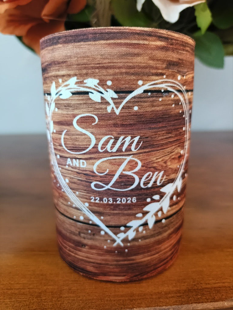 Wooden-patterned tumbler with 'Sam and Ben' and a date engraved on it, placed on a wooden surface.