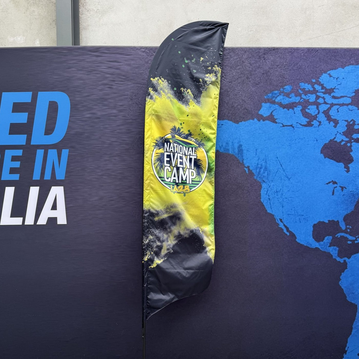 Swooper flag with 'National Event Camp' design against a world map background