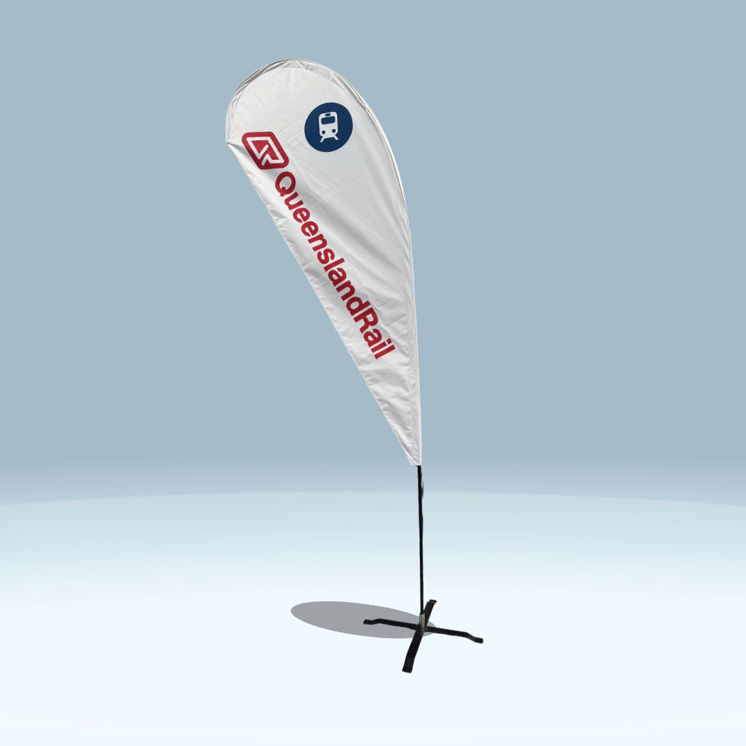 The Teardrop Flag displays the Queensland Rail logo and red text with a blue train icon on a white background. It stands on a black cross base, set against a plain light blue backdrop, ideal for event signage or custom flag use.
